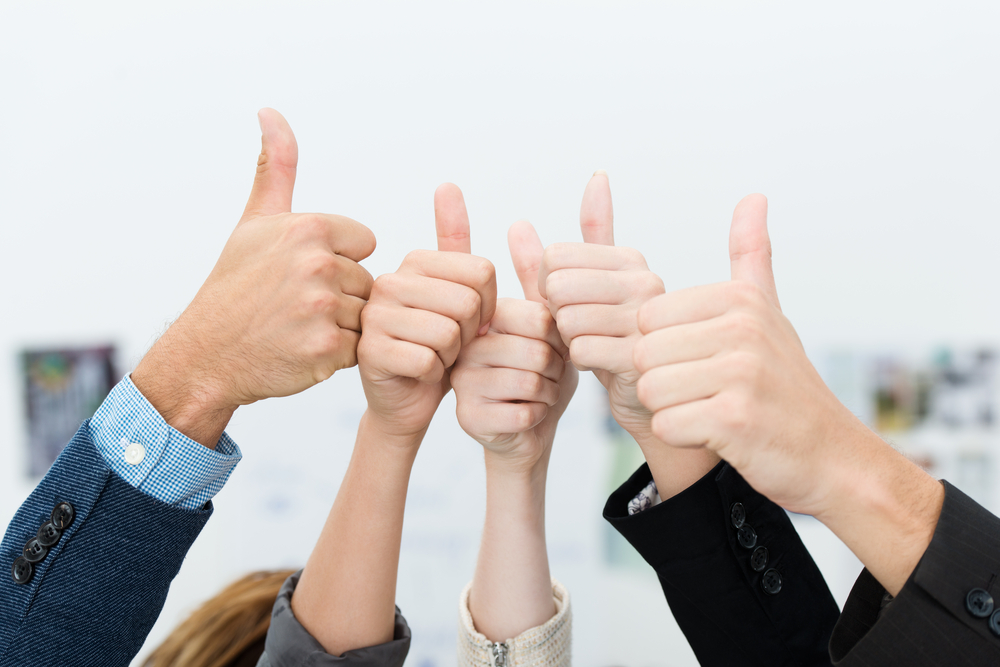 Five hands all doing a thumbs up sign